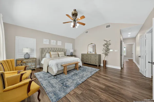 a spacious bedroom with a bed a couch and a chandelier