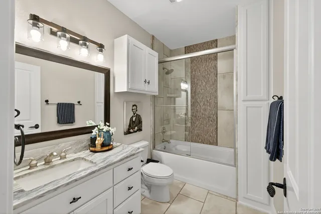 a bathroom with a double vanity sink toilet and shower