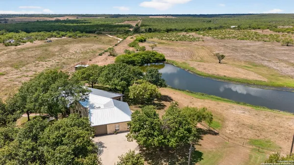 a view of a lake with beach and large trees