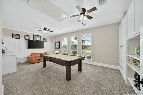 a living room with furniture pool table and a window