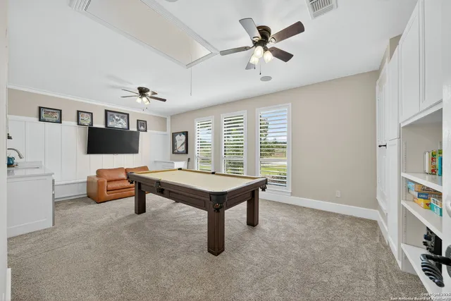 a living room with furniture pool table and a window