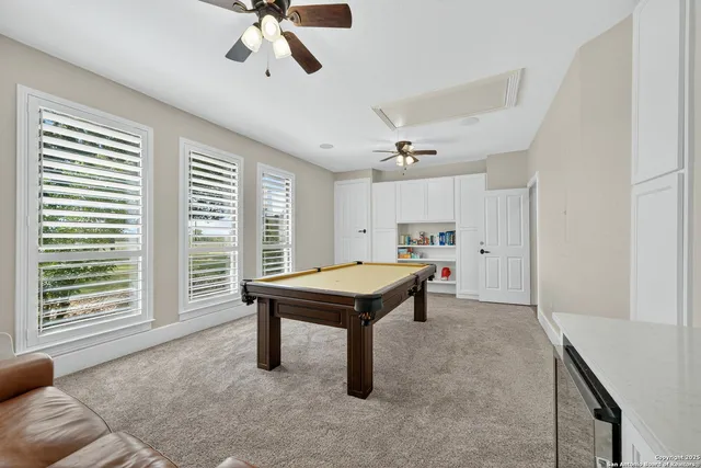 a room with pool table and windows