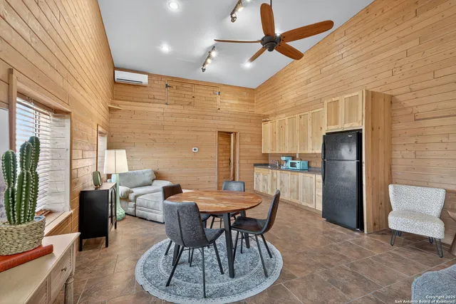 a dining room with furniture a flat screen tv and a large window