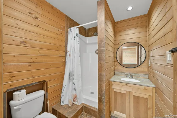 a bathroom with a toilet a sink and a mirror