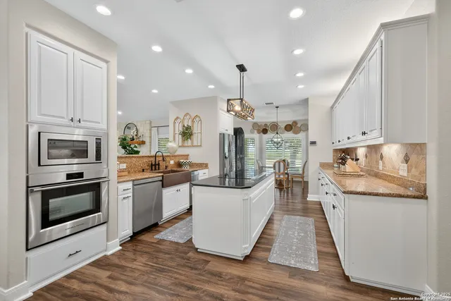 a large kitchen with stainless steel appliances and a stove top oven