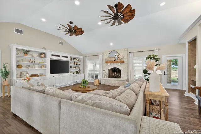 a living room with furniture a fireplace and a flat screen tv