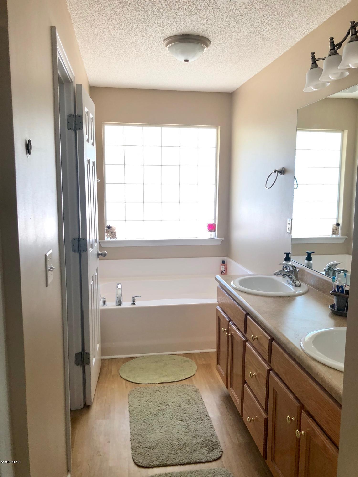 445 Childs Road Roberta, GA 31078 - Photo 11 of 23 a bathroom with a tub sink and mirror