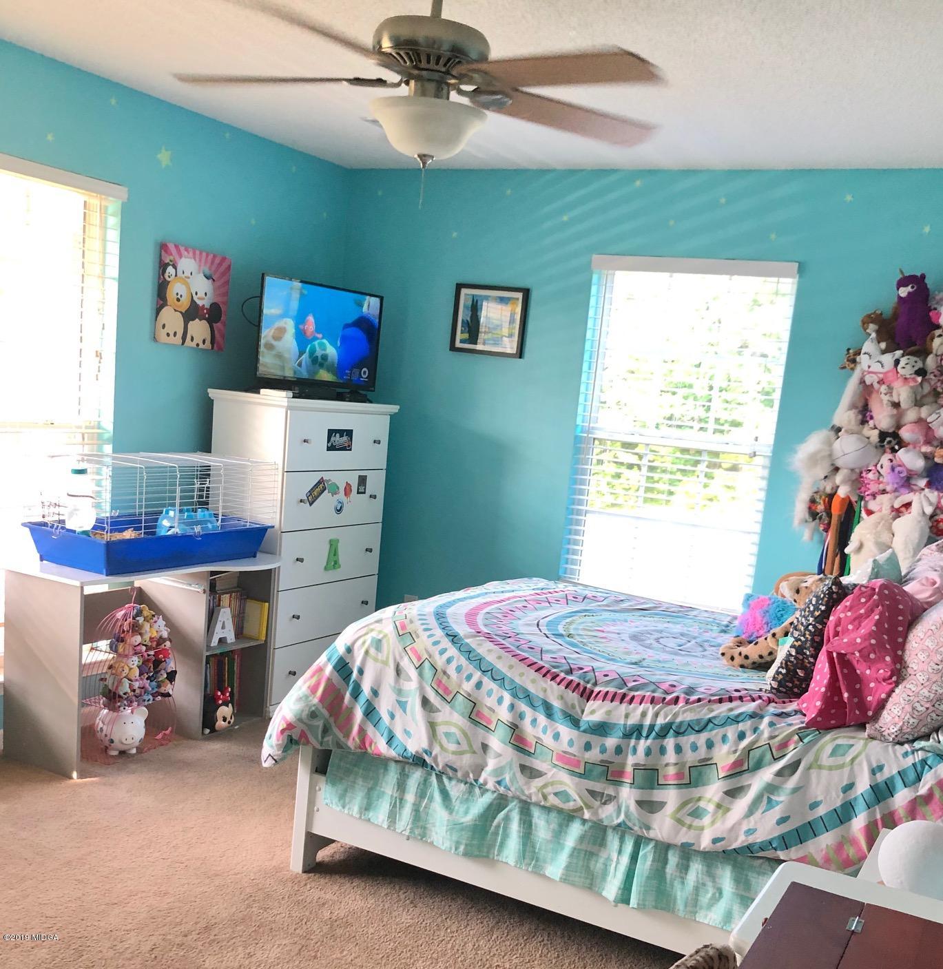 445 Childs Road Roberta, GA 31078 - Photo 12 of 23 a bedroom with a bed and a chandelier