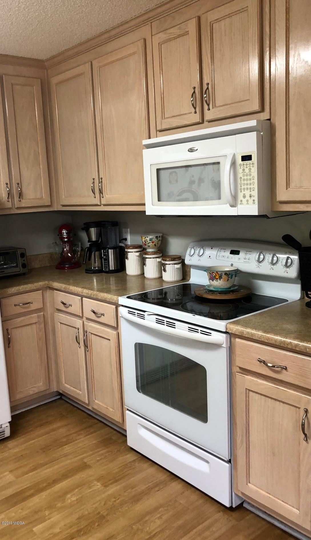 445 Childs Road Roberta, GA 31078 - Photo 3 of 23 a kitchen with granite countertop white cabinets and white appliances