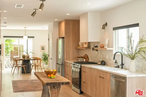 a kitchen with a table chairs stove and kitchen view