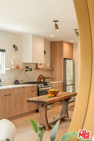 a room with a table chairs wooden floor and a window