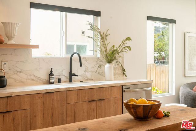 a bathroom with a sink a potted plant and a window