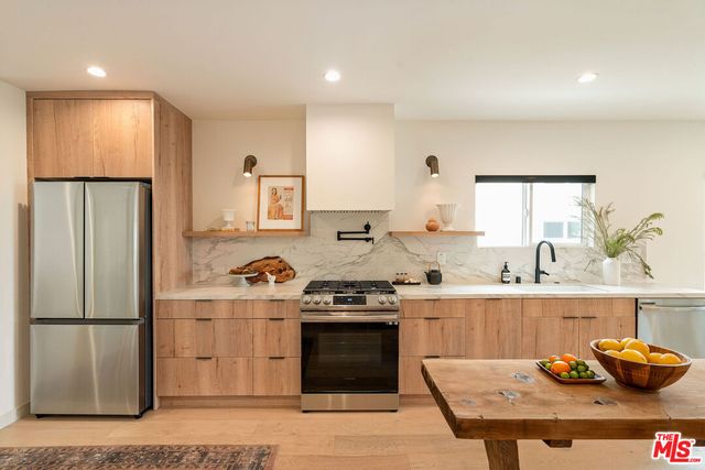 a kitchen with stainless steel appliances granite countertop a stove a refrigerator and a sink