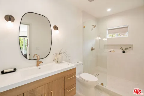 a bathroom with a sink a toilet and a mirror