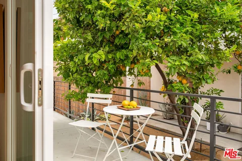 a patio with table and chairs and potted plants