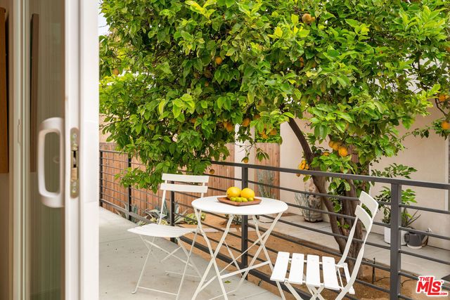 a patio with table and chairs and potted plants