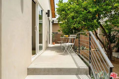 a balcony with wooden floor and outdoor seating