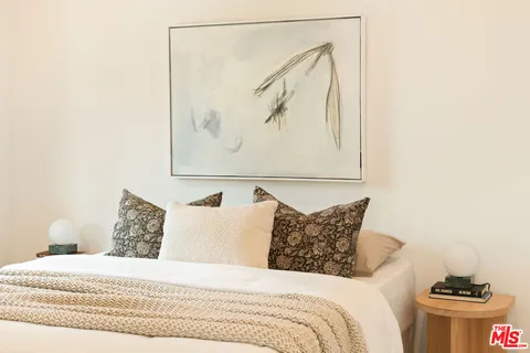 a bedroom with a bed and a painting on the wall