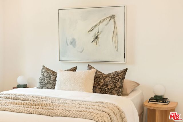 a bedroom with a bed and a painting on the wall