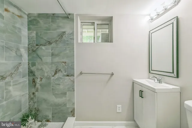 a bathroom with a sink a window and shower