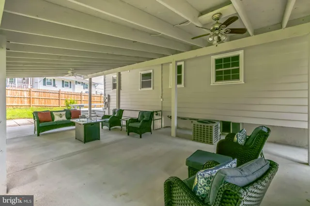 a view of a patio with couches chairs and a wooden floor