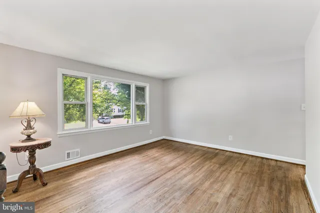 a view of a livingroom with wooden floor and a window