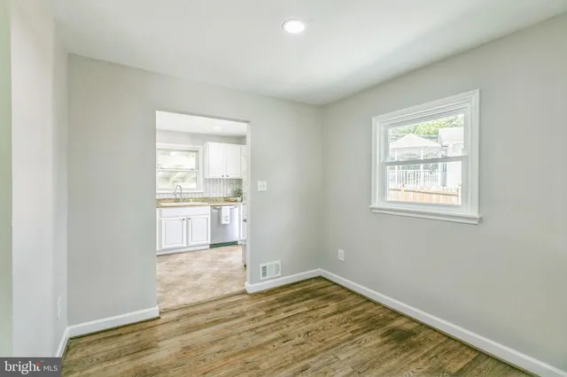 a view of a kitchen with wooden floor and a kitchen space