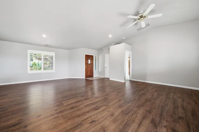 an empty room with a window and a fan