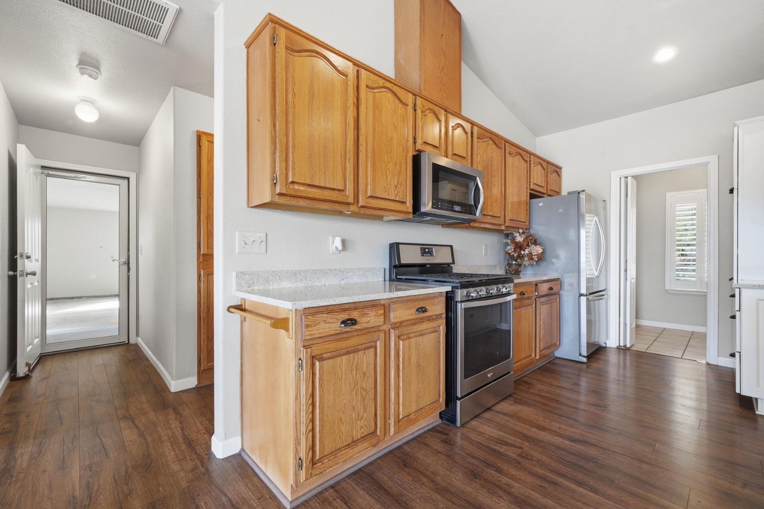 10370 Spunn Road Jackson, CA 95642 - Photo 52 of 87 a kitchen with stainless steel appliances granite countertop a refrigerator a stove top oven and wooden floor
