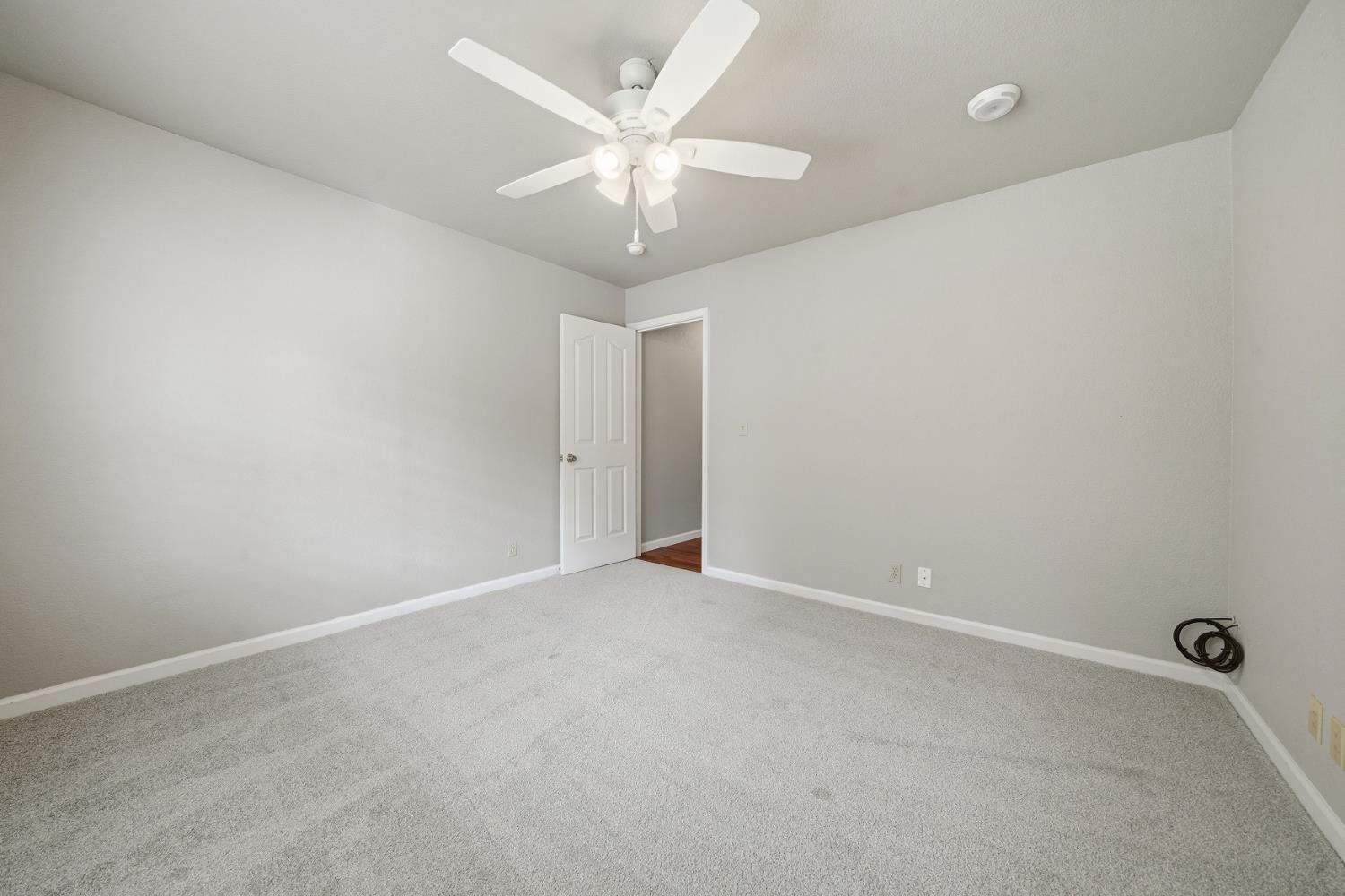 10370 Spunn Road Jackson, CA 95642 - Photo 74 of 87 an empty room with a chandelier fan and windows