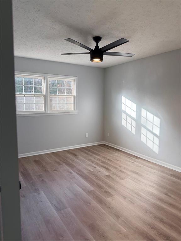 4330 Dogwood Farm Road Lithonia, GA 30038 - Photo 10 of 11 an empty room with wooden floor fan and windows