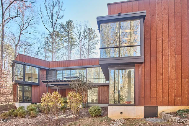 a front view of a building with large windows and a potted plant