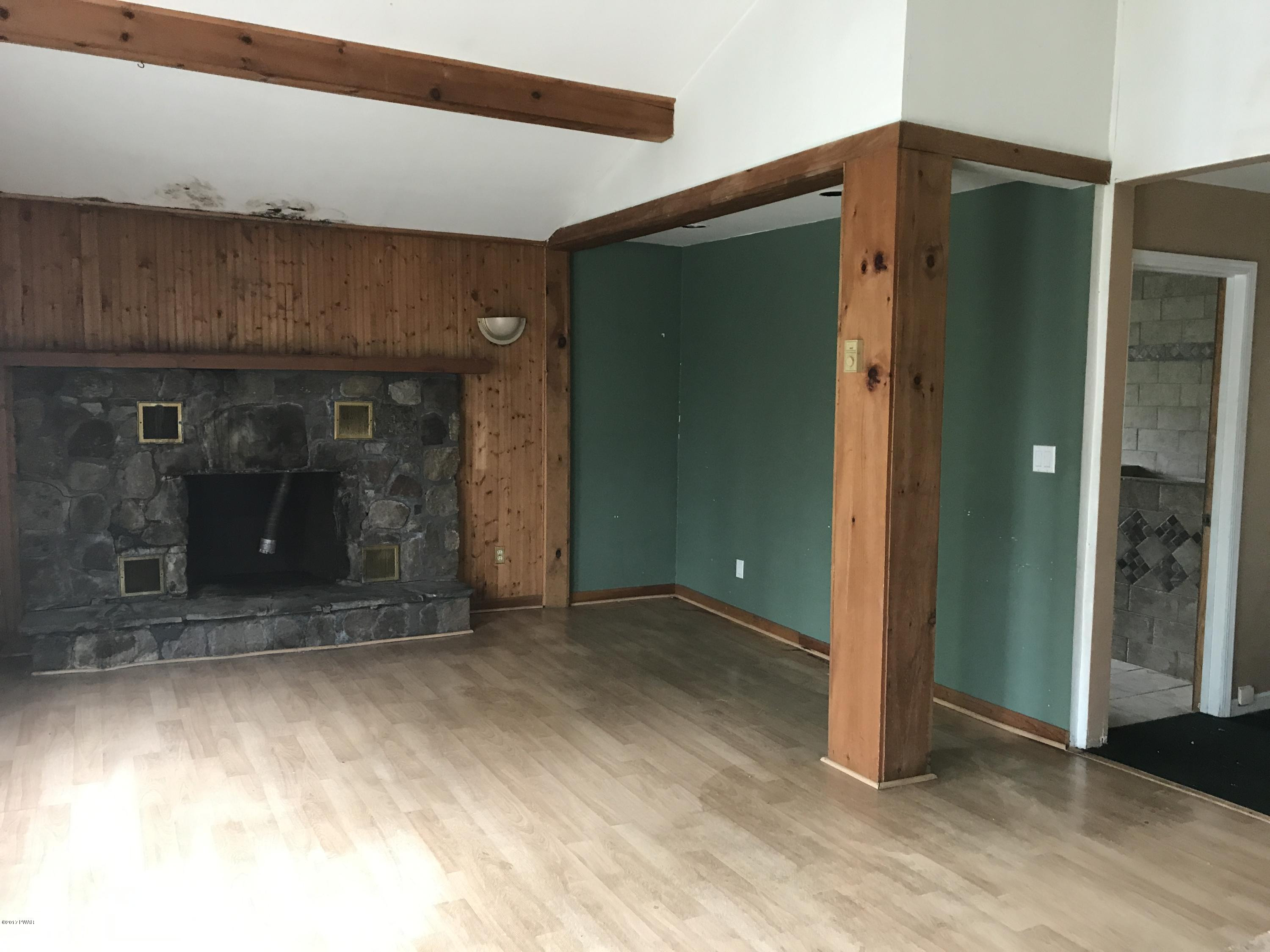 146 Weasel Road Dingmans Ferry, PA 18328 - Photo 4 of 15 a view of empty room with window and fireplace