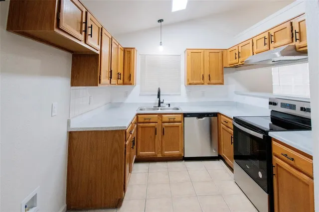 a kitchen with stainless steel appliances granite countertop a sink and a stove