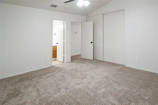 a view of an empty room and chandelier fan