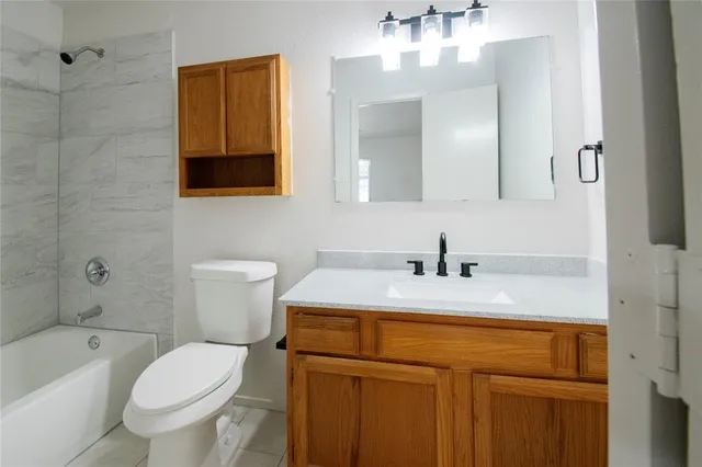 a bathroom with a sink vanity mirror and toilet