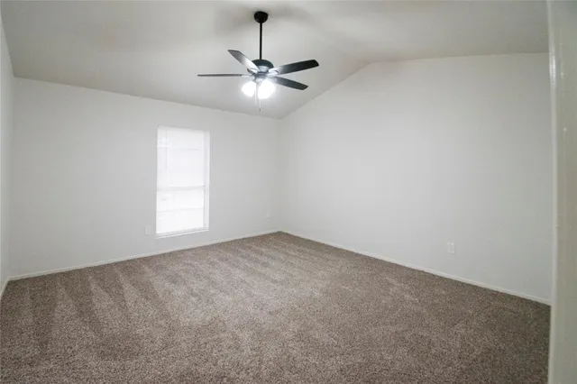 en empty room with windows and chandelier fan