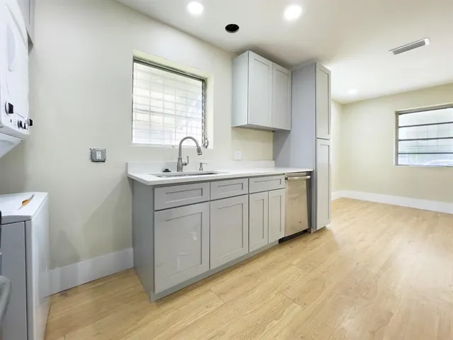 a kitchen with a sink cabinets appliances and a window