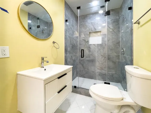 a bathroom with a toilet sink and mirror