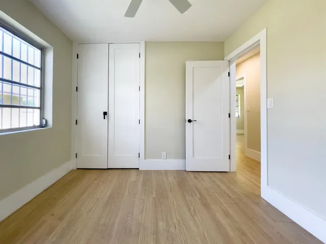 an empty room with wooden floor and windows