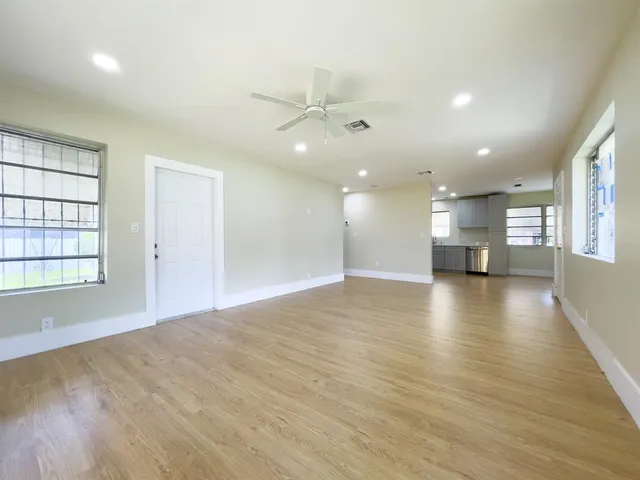 an empty room with a kitchen and windows