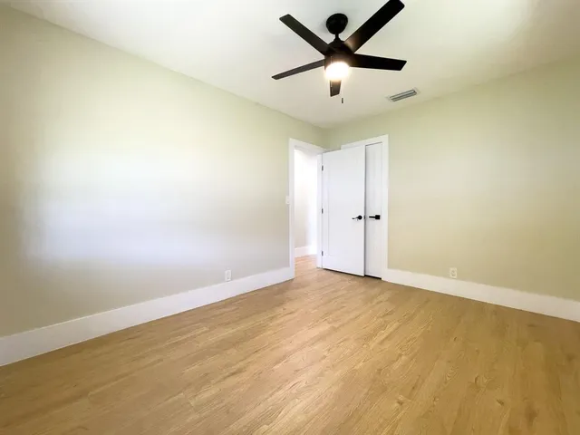 an empty room with closet and windows