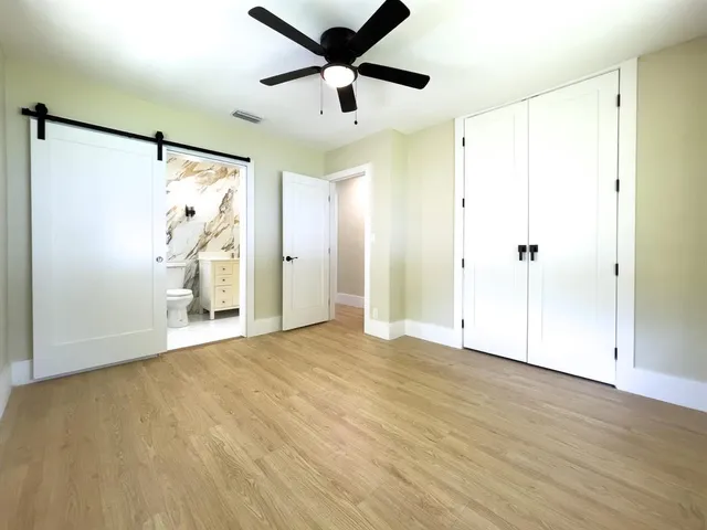 a view of an empty room with cabinet and a ceiling fan