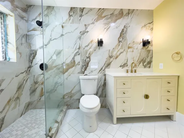 a bathroom with a toilet sink and mirror