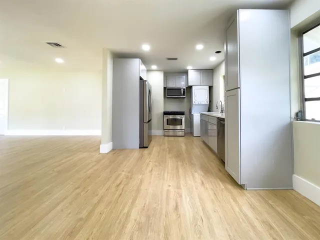 a view of a kitchen with a sink and a refrigerator