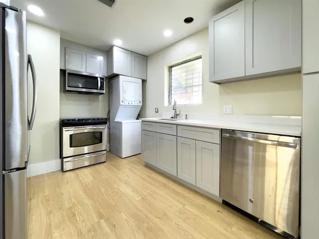 a kitchen with stainless steel appliances a stove a refrigerator and a sink