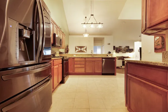 a large kitchen with stainless steel appliances granite countertop a stove and a sink