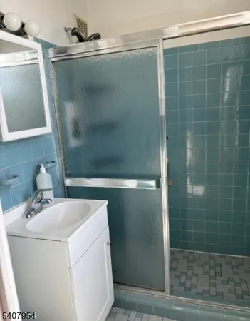 a bathroom with a sink a glass door shower and a mirror