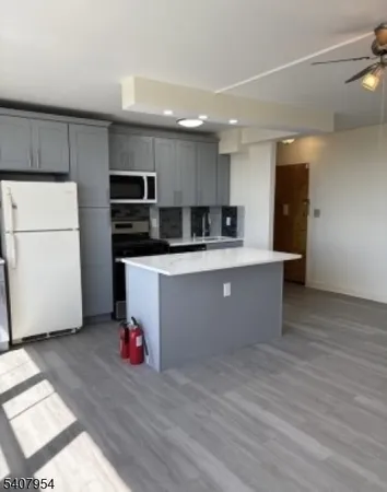 a large kitchen with stainless steel appliances a refrigerator and a stove