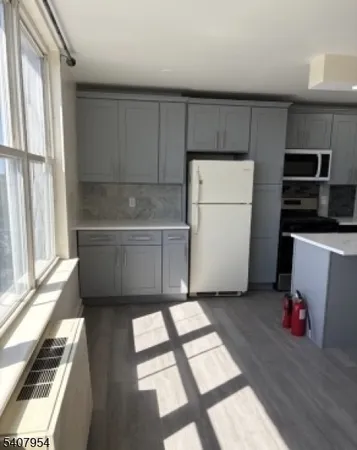a kitchen with a refrigerator and a stove top oven